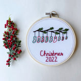 This is a 4 inch embroidery hoop with white fabric and a green and mint butterfly embroidered in the center. under the butterfly is a baby name stitched in black with the date underneath.