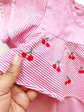 Close Up. A red and pink striped children's shirt with small embroidered cherries in the middle.